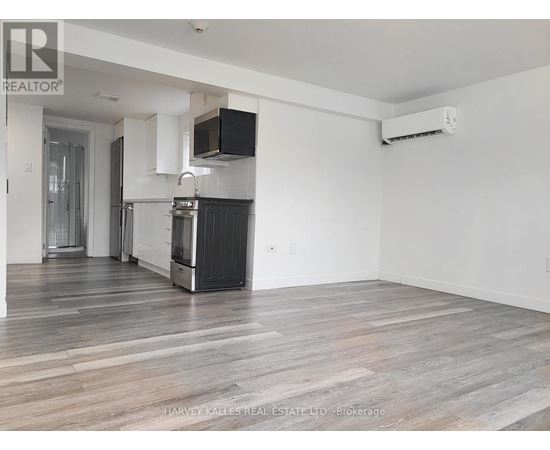 A spacious kitchen with white cabinets and a black stove top oven.