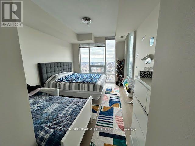 A bedroom with two beds and a window overlooking a cityscape.
