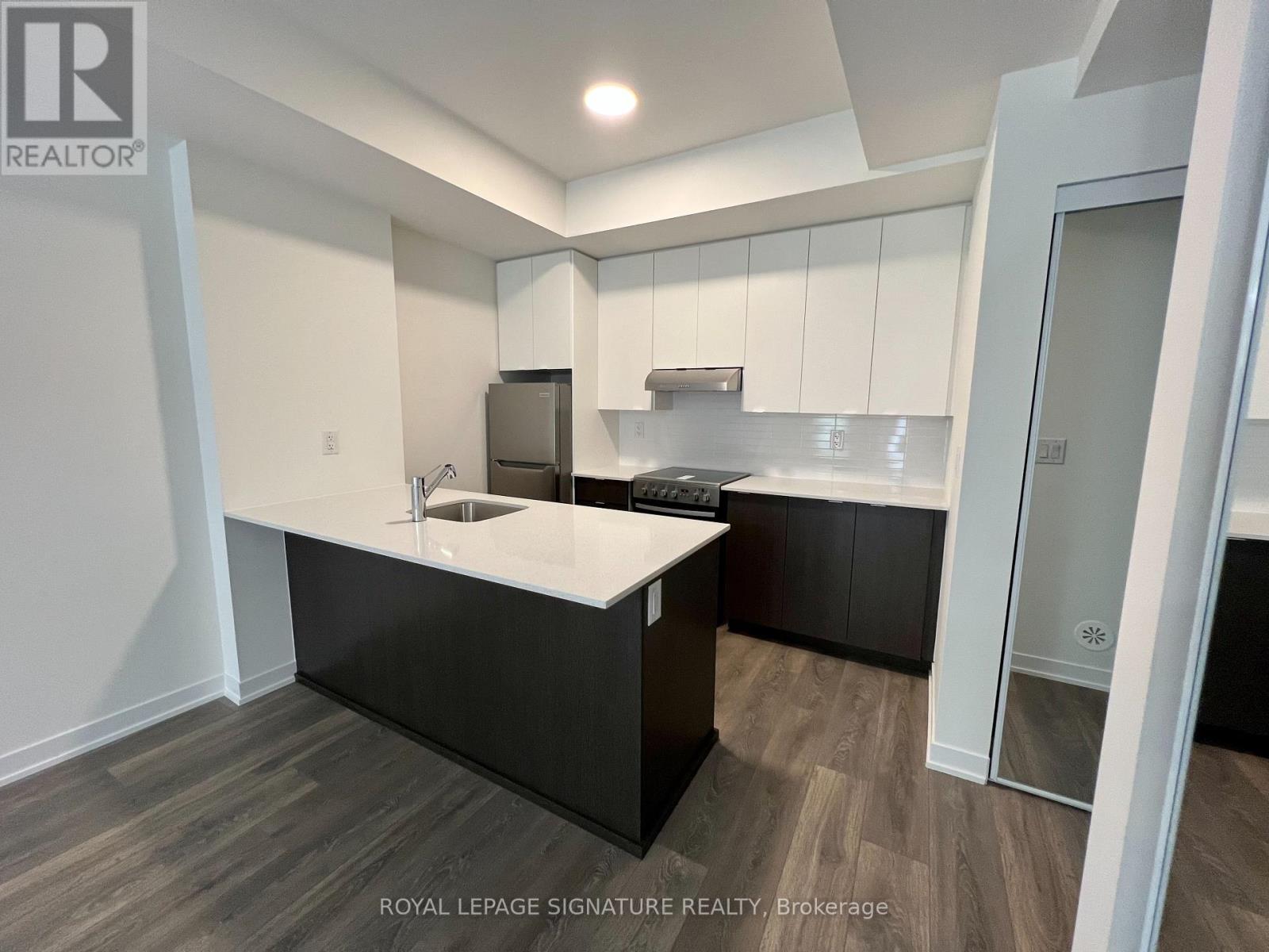 A kitchen with white countertops and black cabinets.