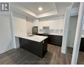 A kitchen with white countertops and black cabinets.