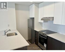 A kitchen with a sink, refrigerator, and stove.