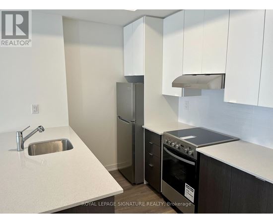 A kitchen with a sink, refrigerator, and stove.
