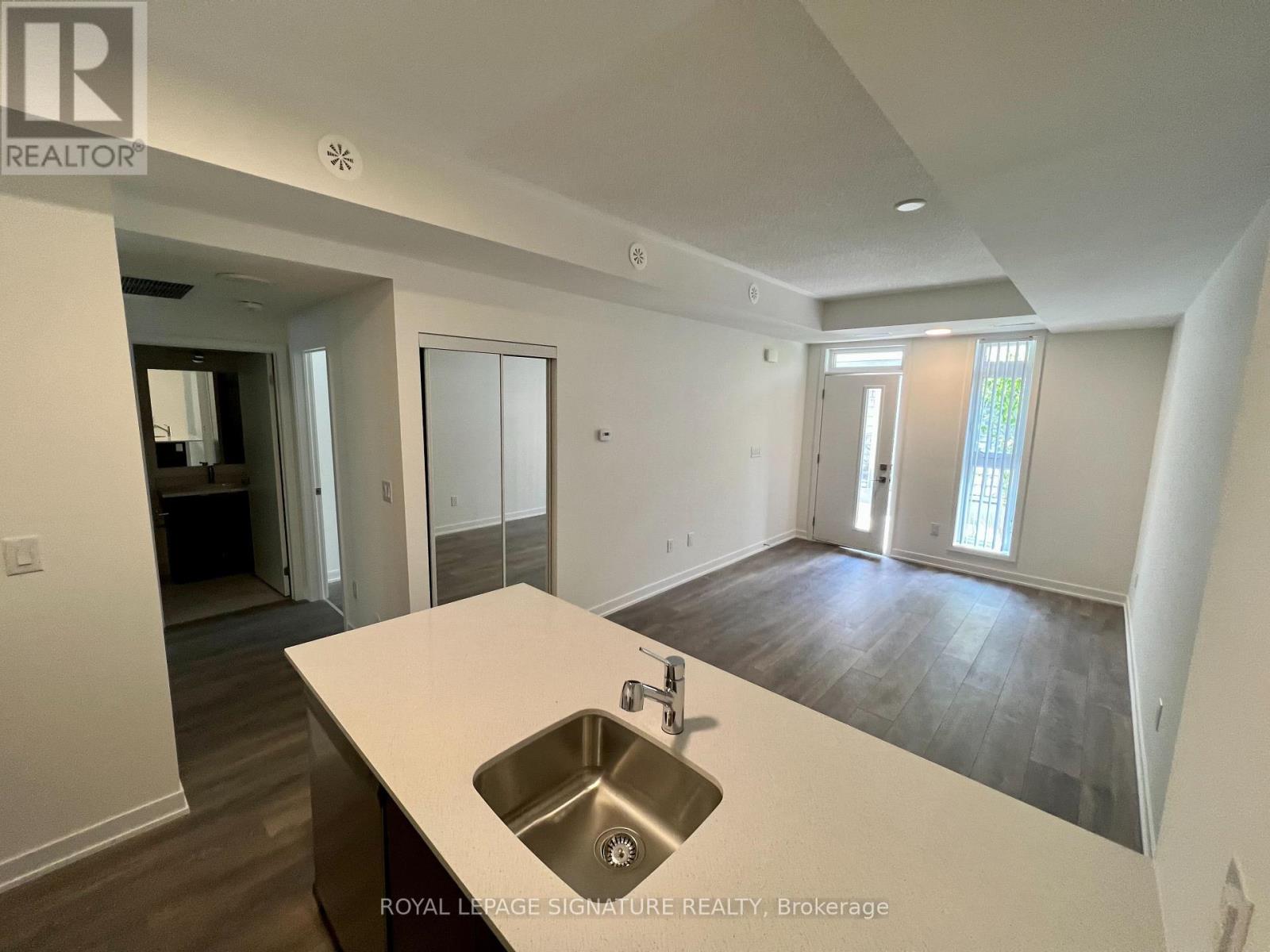 A spacious kitchen with a sink and a countertop.