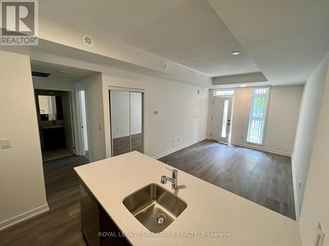 A spacious kitchen with a sink and a countertop.