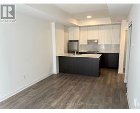 A kitchen with a black counter top and white cabinets.