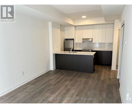 A kitchen with a black counter top and white cabinets.