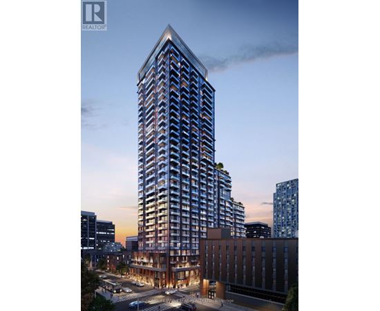 A tall building with a glass facade stands in the foreground of a cityscape at dusk.