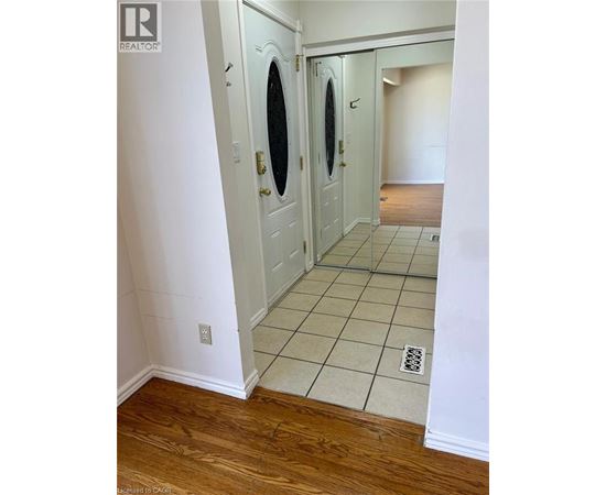 A white door with a round window is in a hallway.