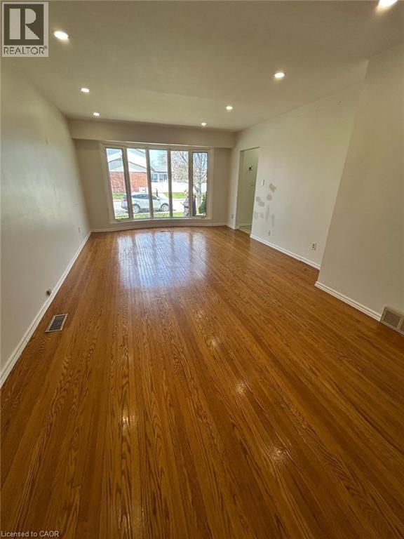 A room with wooden flooring and a sliding glass door.