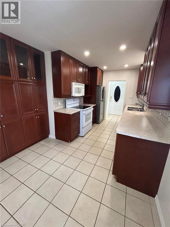 A kitchen with brown cabinets and a white fridge.