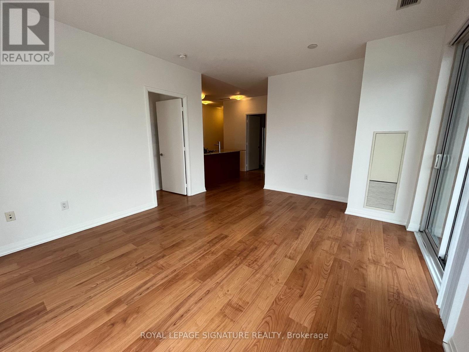 A room with wooden flooring and white walls.