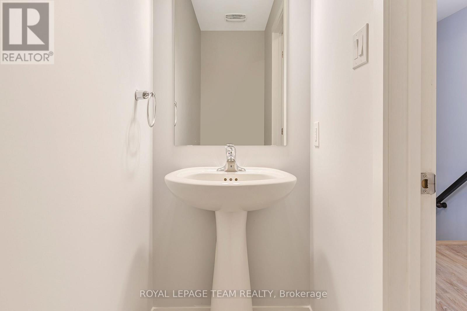 A white pedestal sink in a small bathroom.