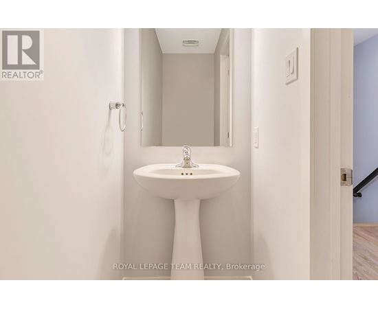 A white pedestal sink in a small bathroom.