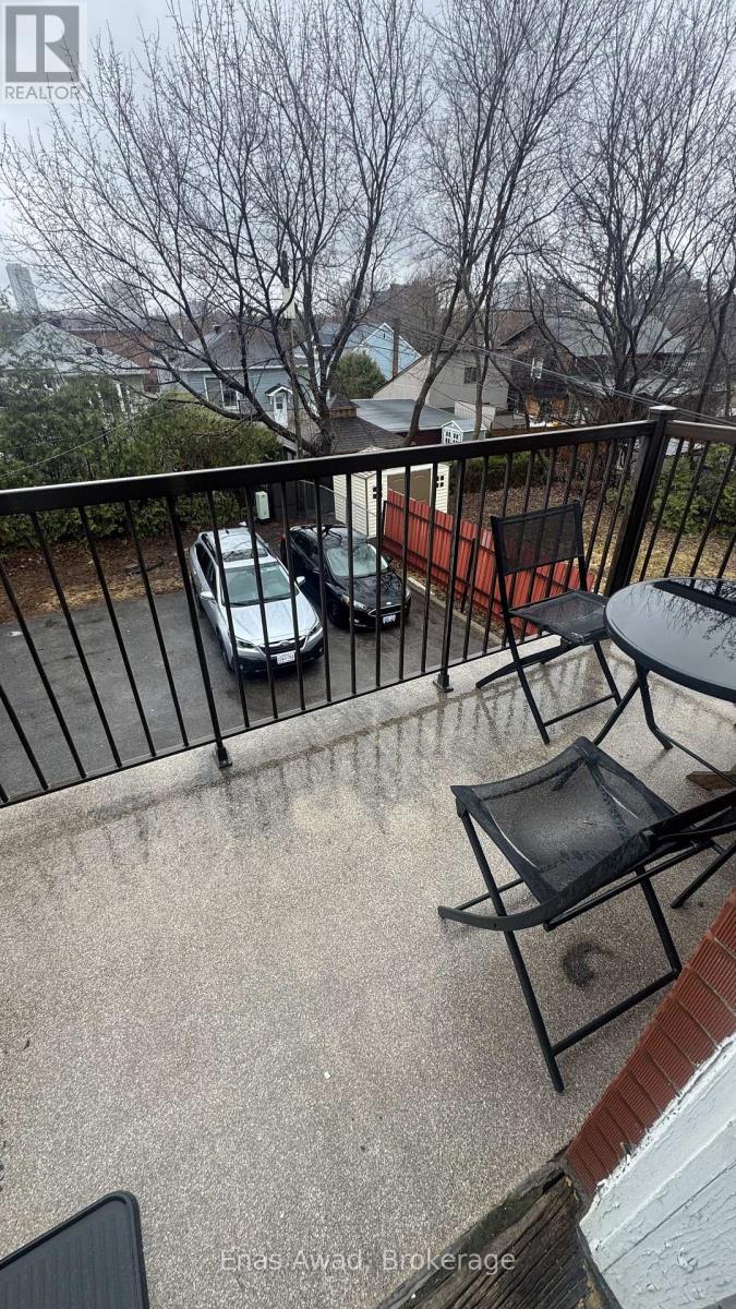A balcony with a black chair and a table.
