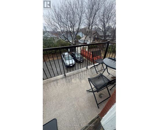 A balcony with a black chair and a table.