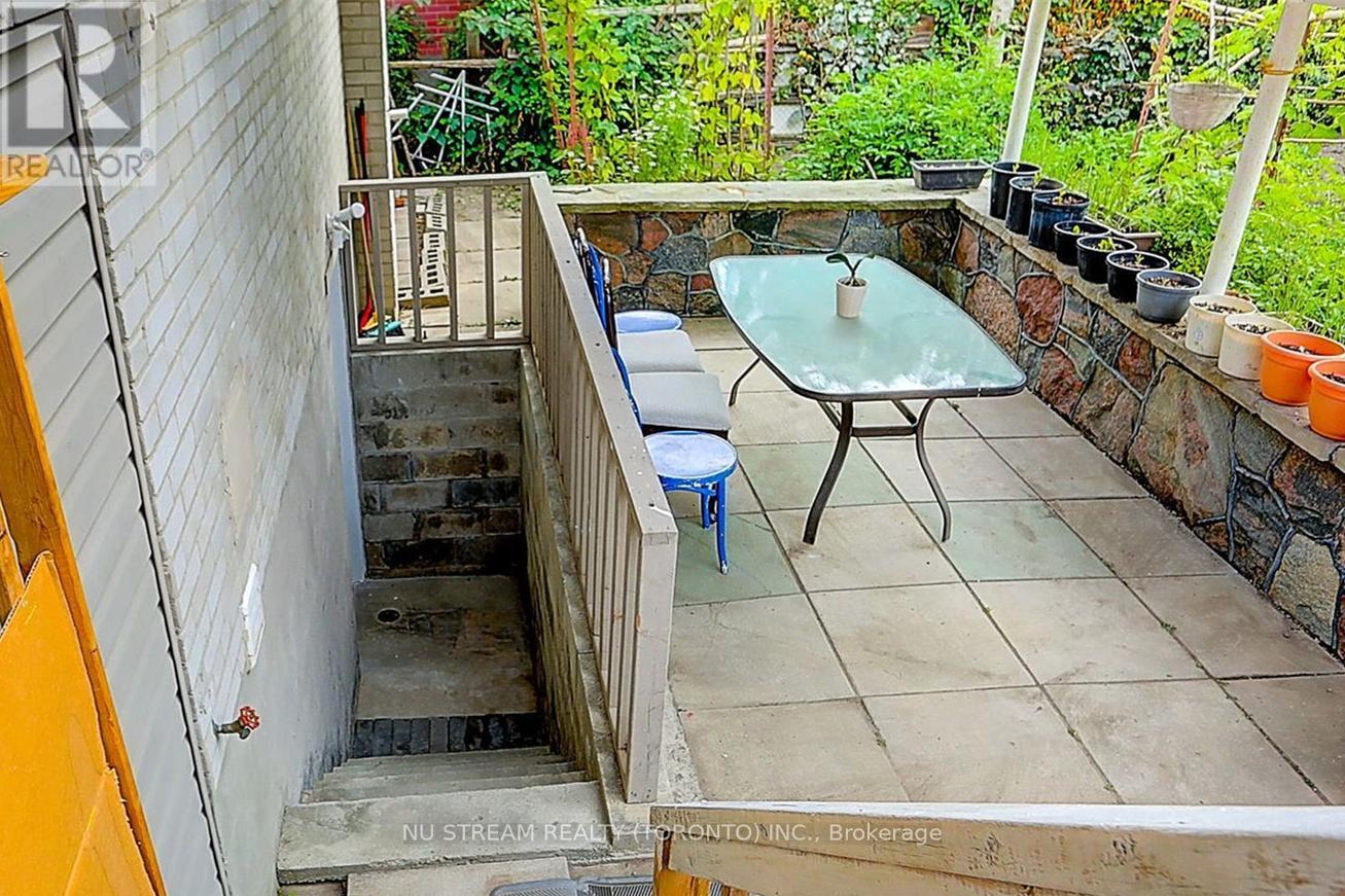 A small table with a glass top is in the middle of a patio.