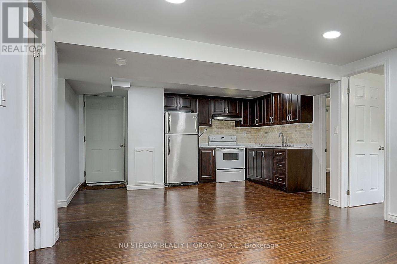 A kitchen with dark wood cabinets and stainless steel appliances.