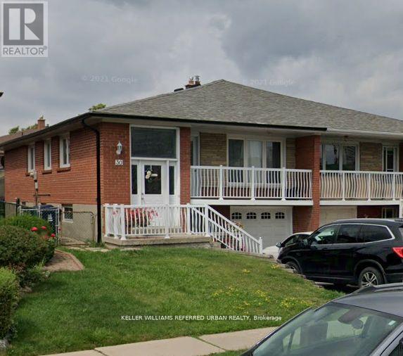 A house with a white fence and a black car parked in front.