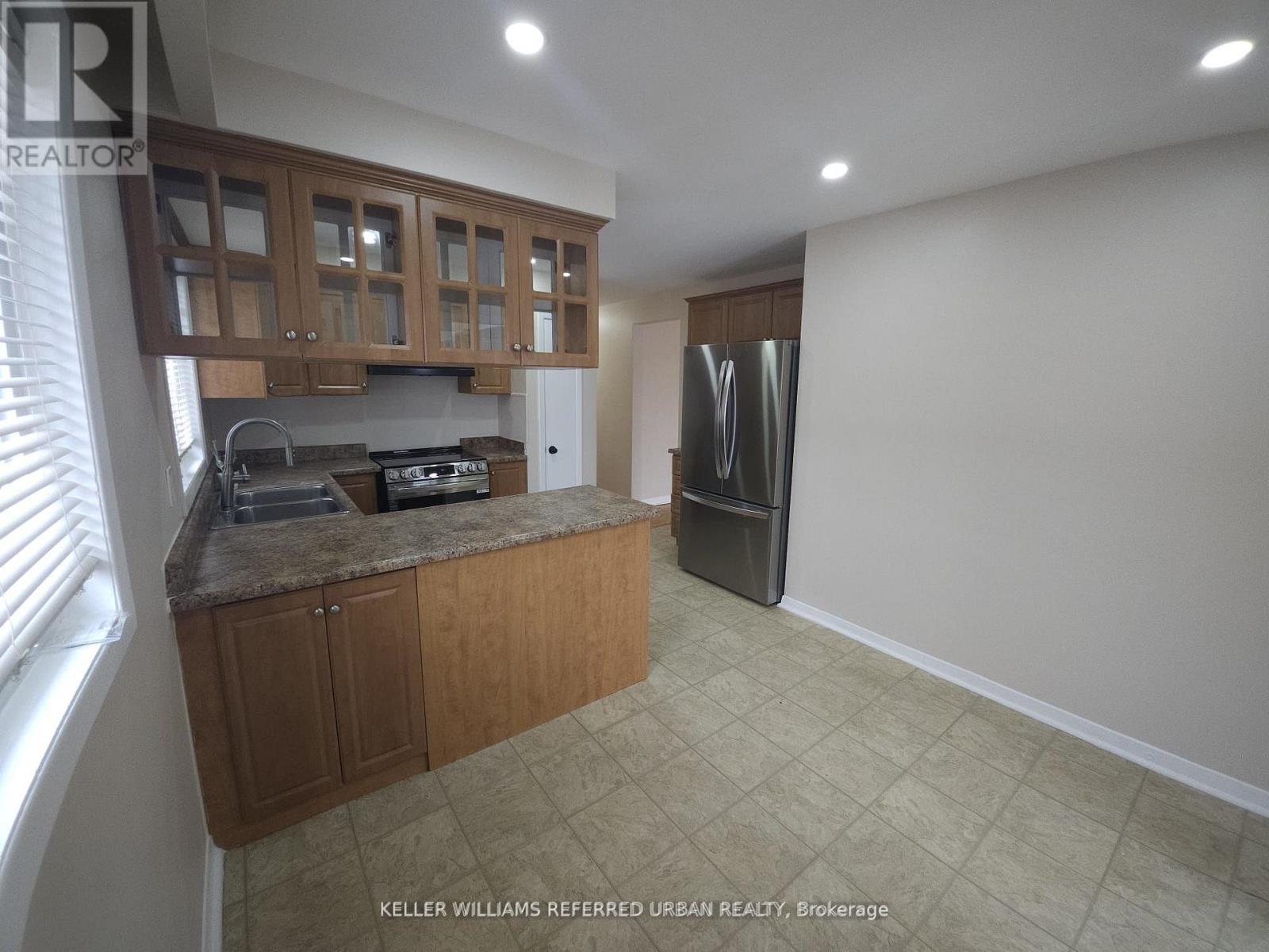 A kitchen with wooden cabinets and a refrigerator.