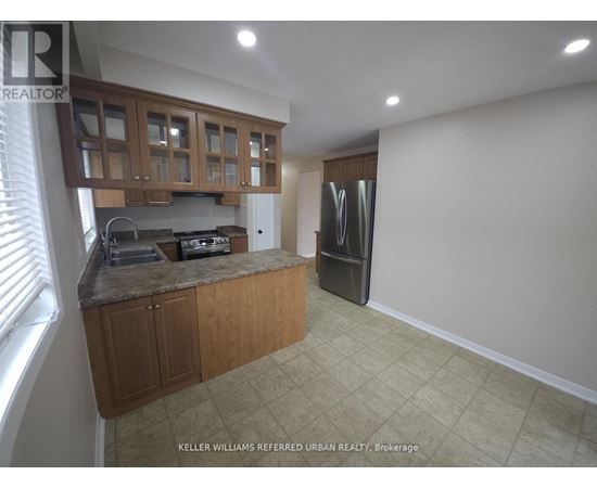 A kitchen with wooden cabinets and a refrigerator.