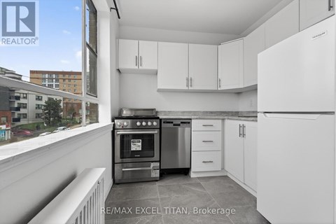 A modern kitchen with white cabinets and stainless steel appliances.