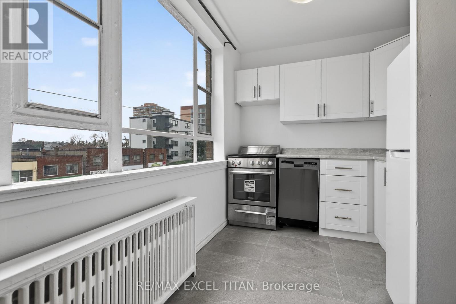 A modern kitchen with white cabinets and stainless steel appliances.