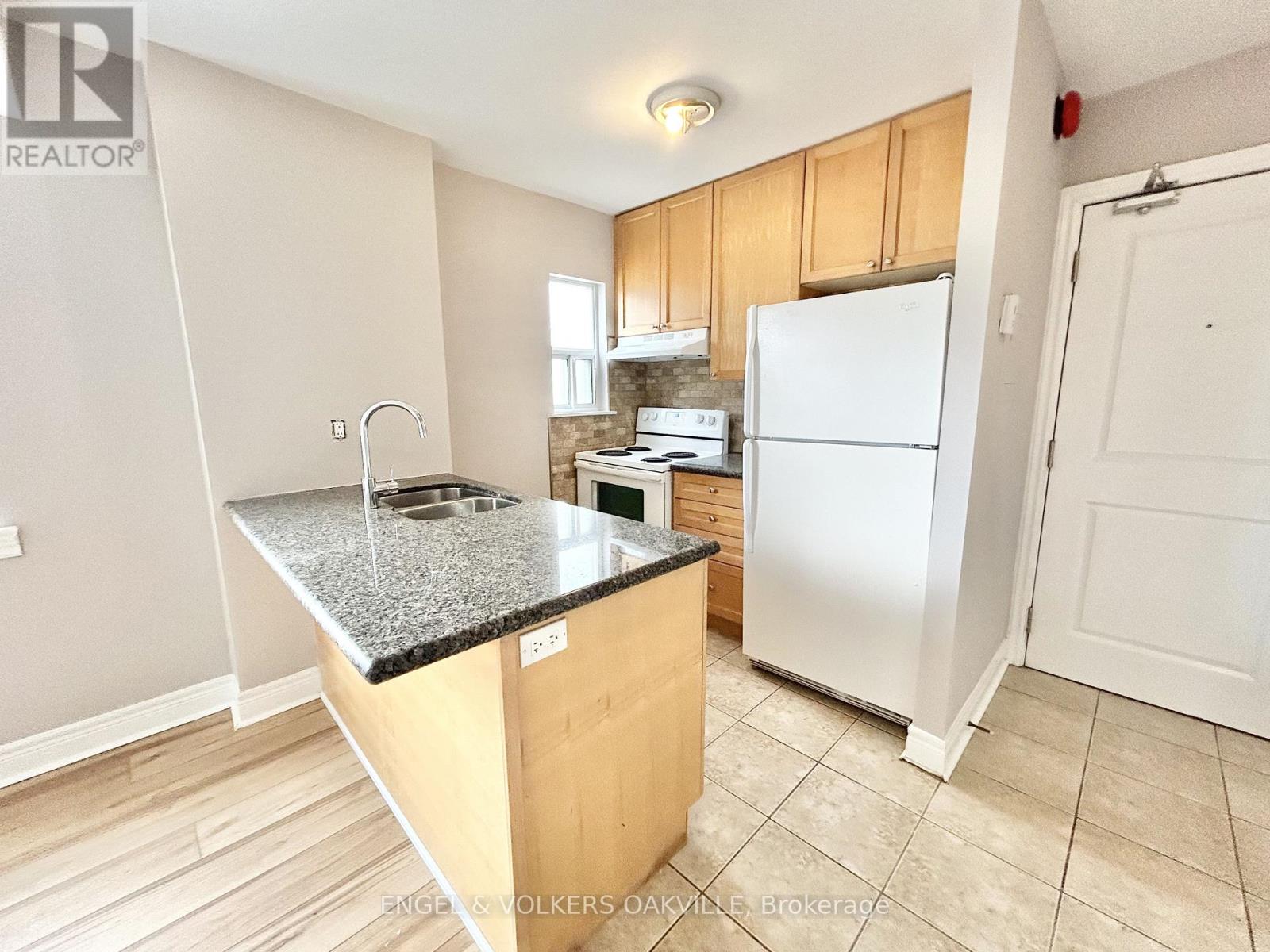 A kitchen with a white fridge and wooden cabinets.