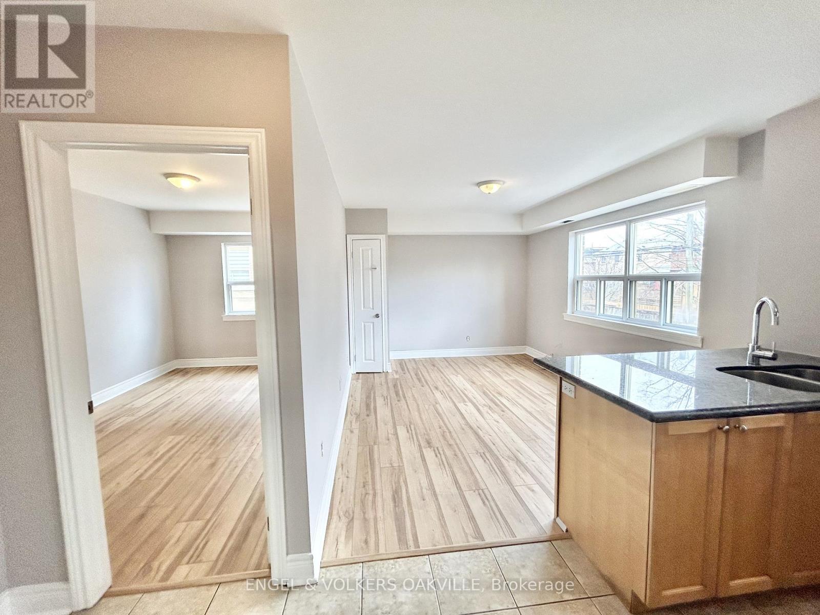 A kitchen with wooden floors and a black countertop.