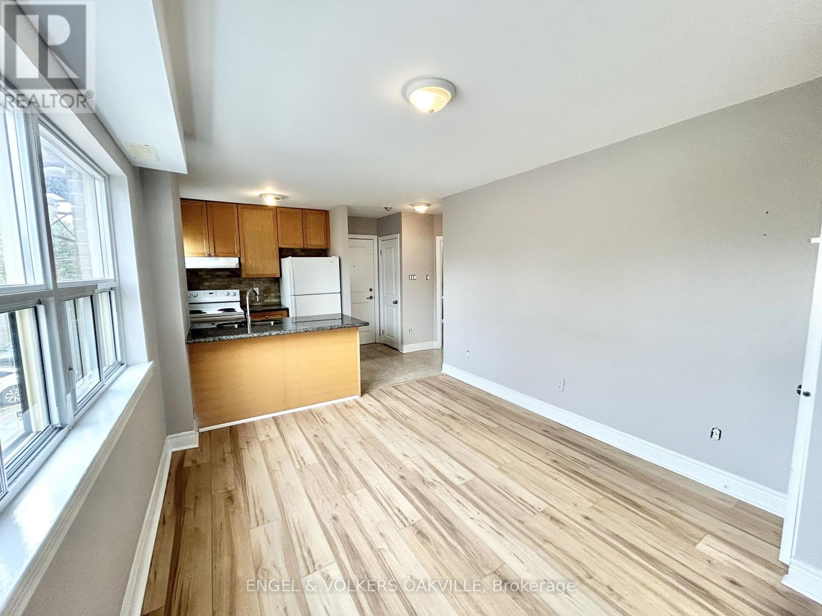 A kitchen with wooden floors and white walls.