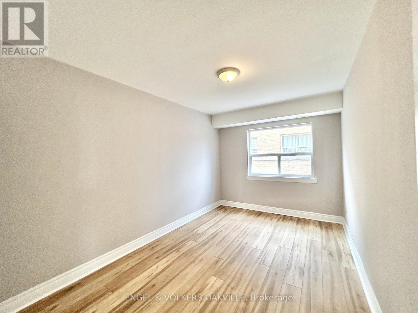 A room with wooden flooring and a window.