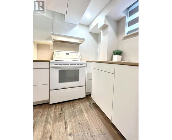 A white stove and oven in a kitchen with wooden flooring.