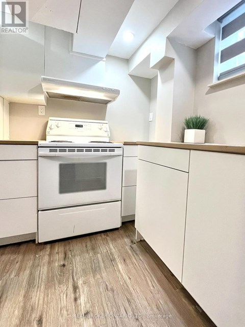 A white stove and oven in a kitchen with wooden flooring.