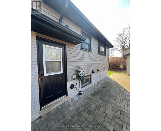 A house with a black door and a window with a white curtain.