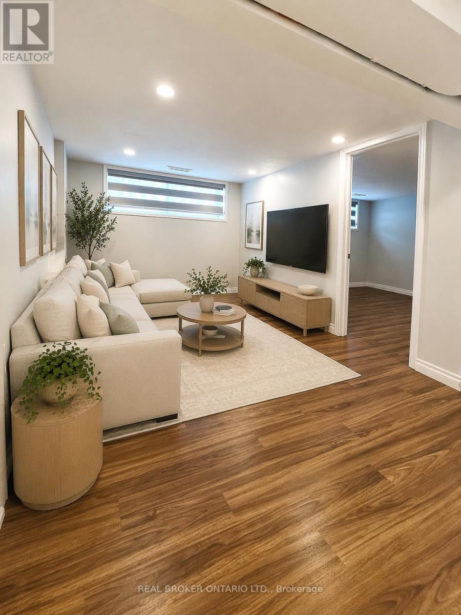 A living room with a white couch, a wooden floor, and a flat screen TV.