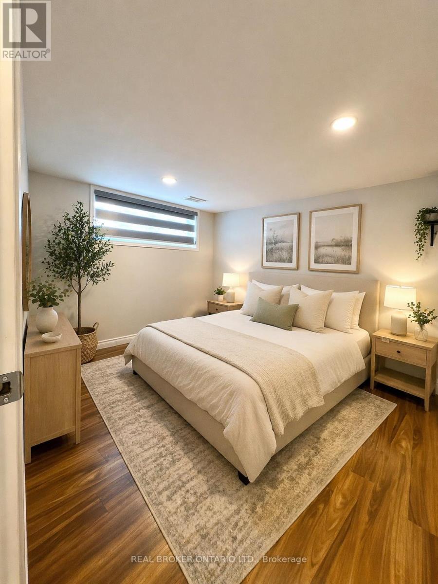 A bedroom with a large bed, a nightstand, and a small tree.