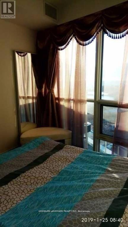 A bedroom with a bed and a window with curtains.