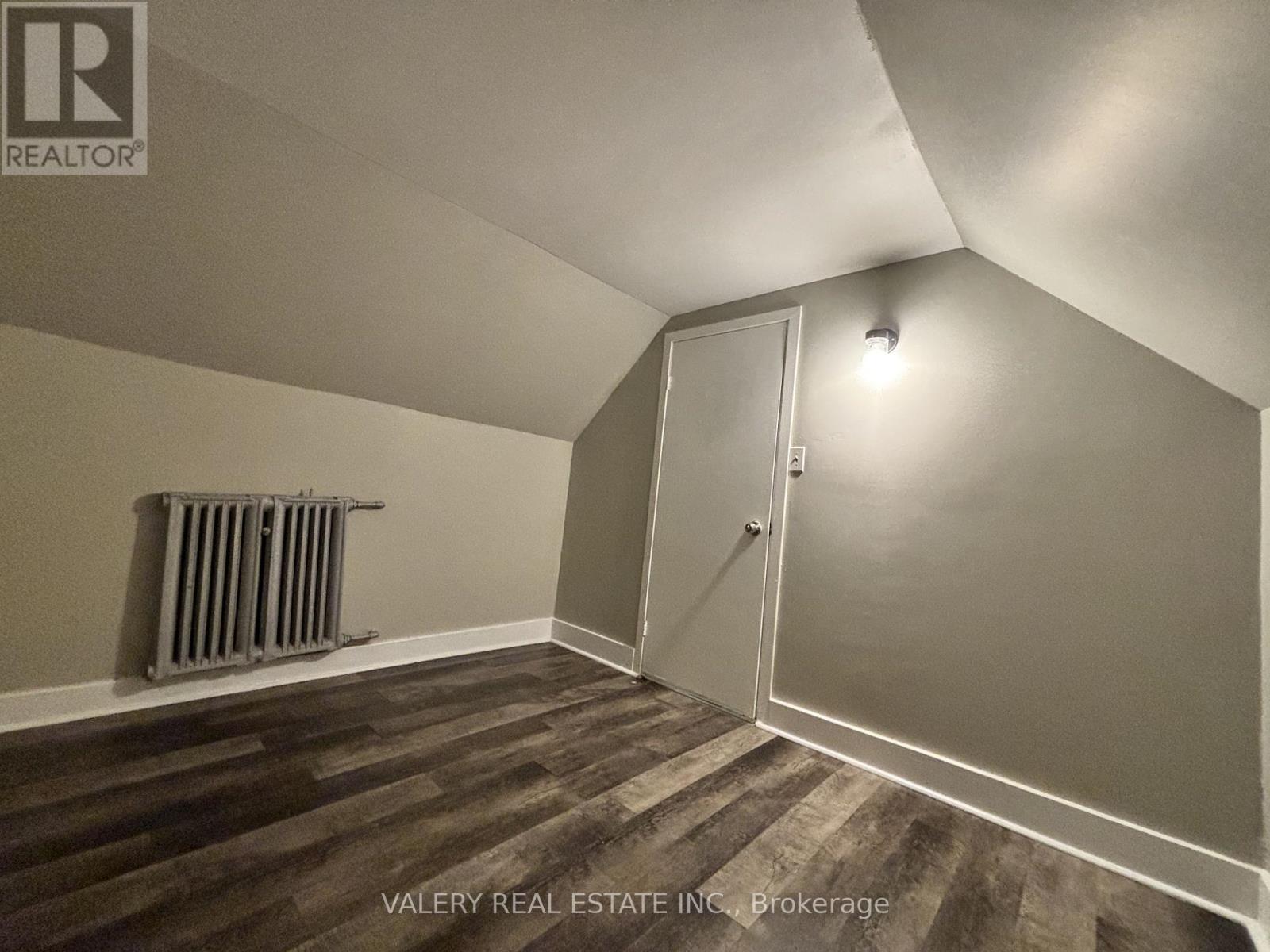 A room with a wooden floor and a white door.