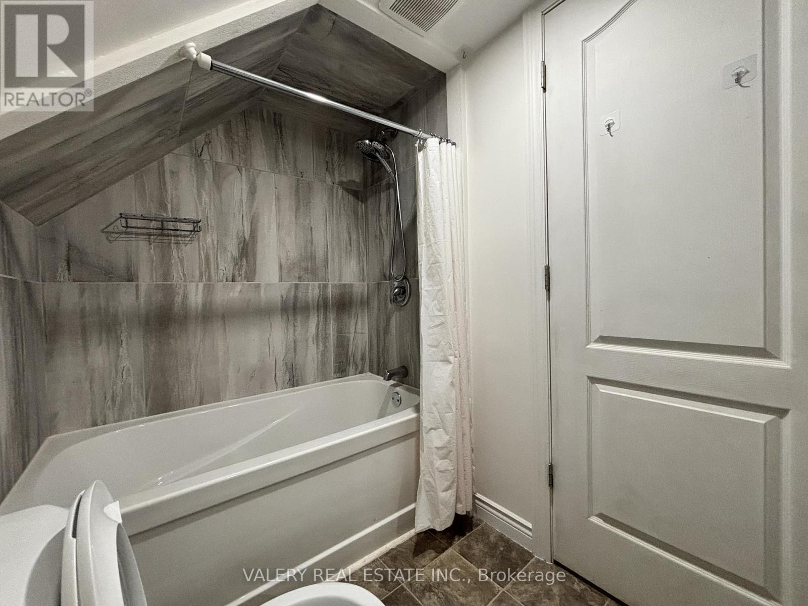 A bathroom with a bathtub and a shower curtain.