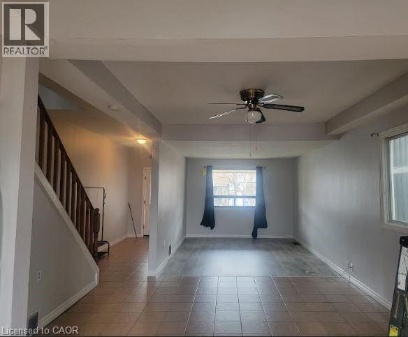 A room with a ceiling fan and tiled floor.