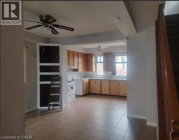 A realtor's photo of a kitchen and living room with a ceiling fan.