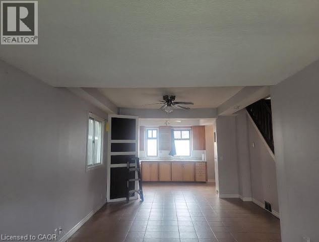 A room with a ceiling fan and tiled flooring.