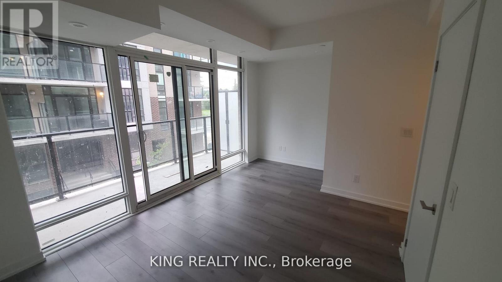 A room with a view of a street through large windows.