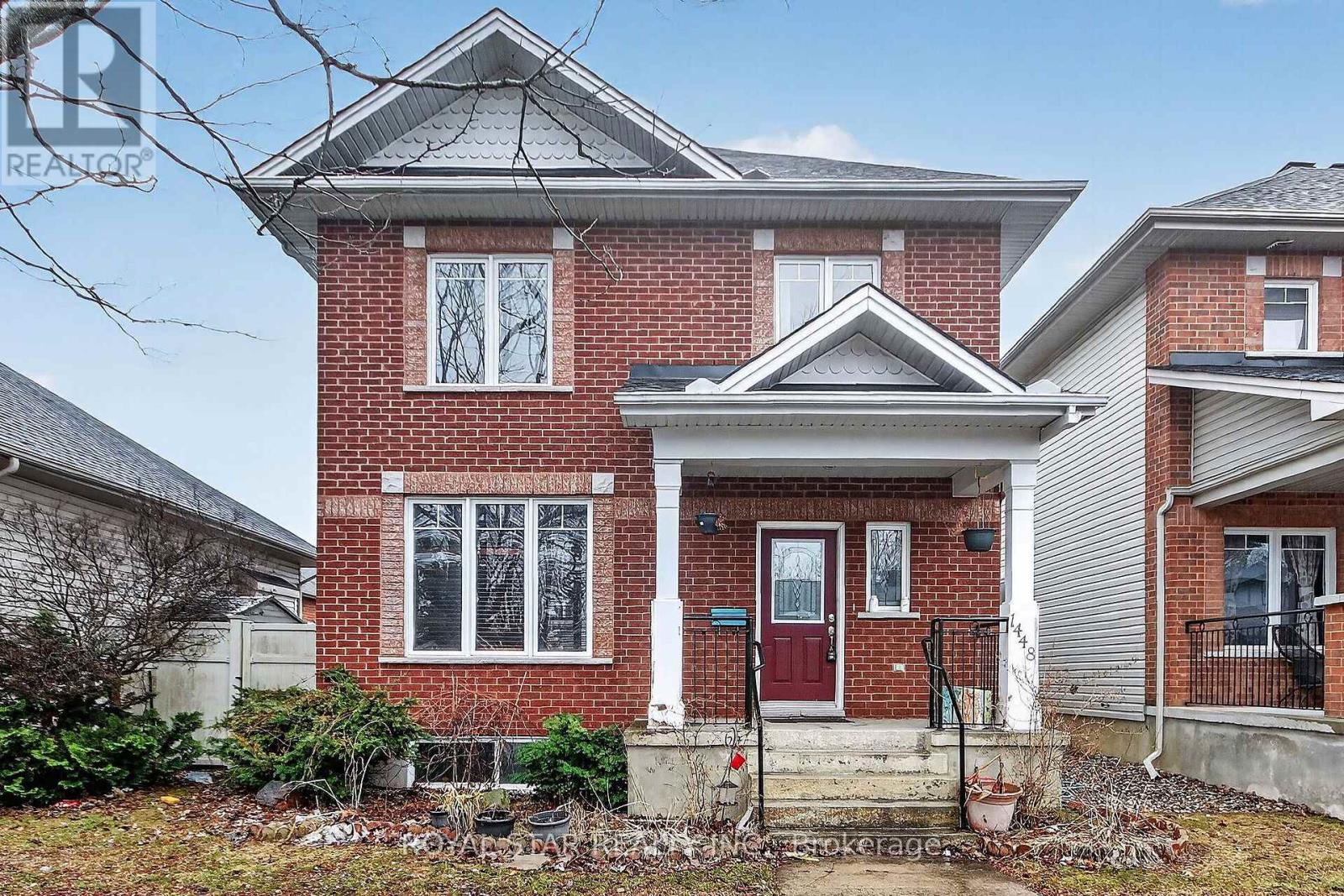 A red brick house with a white door and windows.