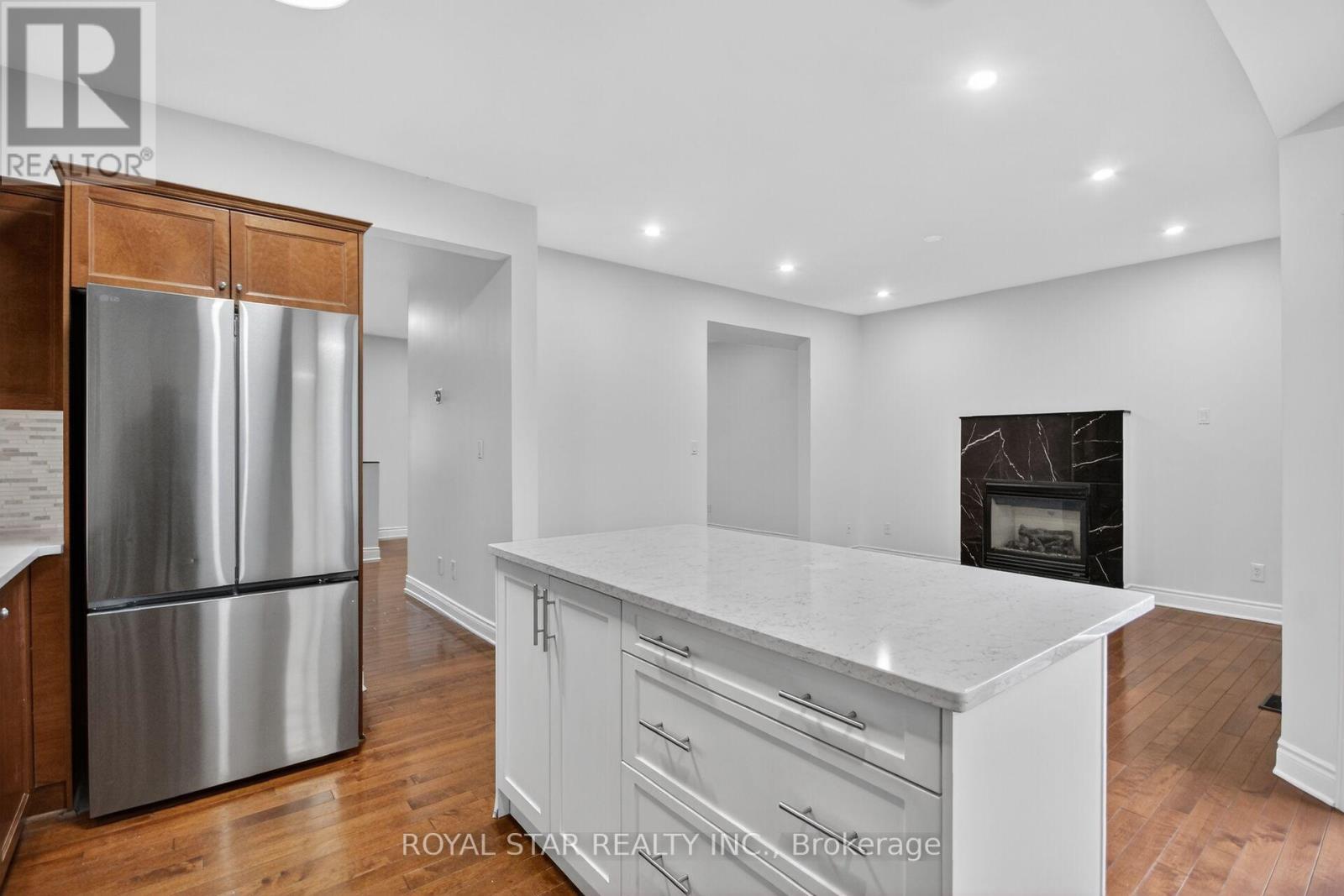 A kitchen with white cabinets and a stainless steel refrigerator.