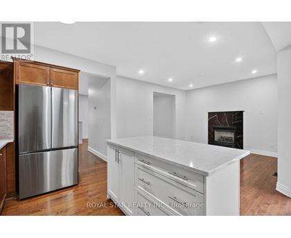 A kitchen with white cabinets and a stainless steel refrigerator.