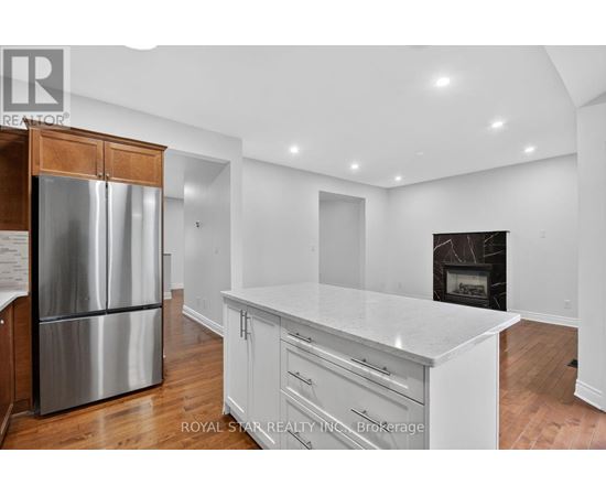 A kitchen with white cabinets and a stainless steel refrigerator.