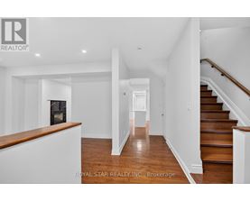 A spacious hallway with a staircase on the right and a fireplace on the left.