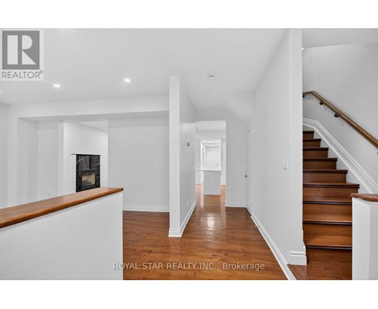 A spacious hallway with a staircase on the right and a fireplace on the left.