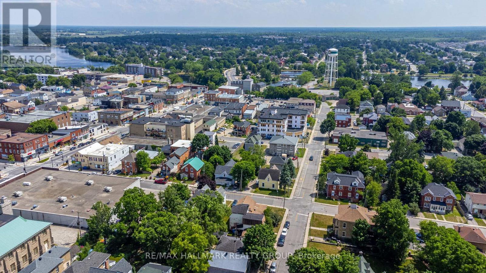 A bird's eye view of a city with buildings, roads, and a body of water in the distance.