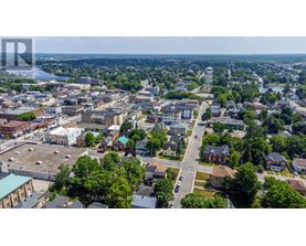 A bird's eye view of a city with buildings, roads, and a body of water in the distance.
